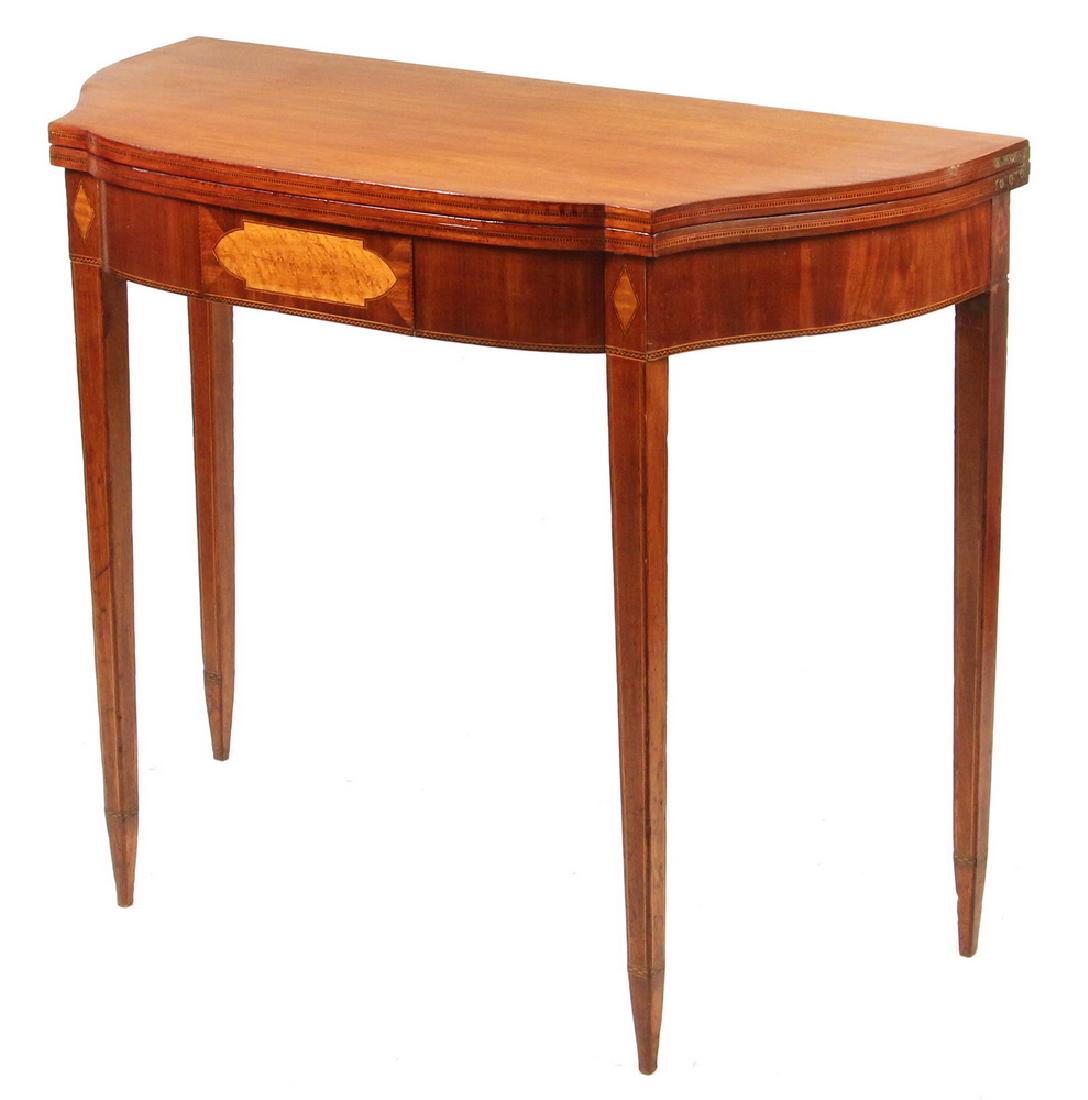 EARLY FEDERAL CARD TABLE: Hepplewhite Mahogany Inlaid Card Table having a shaped bow front with serpentine ends, the top with hinged leaf and conforming shaped frieze, satinwood central panel, with diamond insets at top of leg