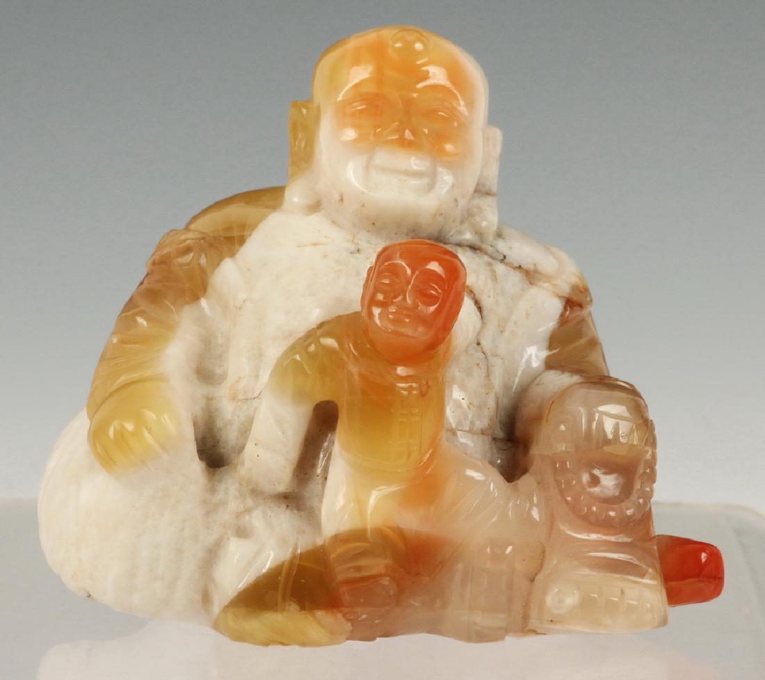 CHINESE CARNELIAN AGATE CARVING OF BUDDHA WITH CHILD: Late 19th to early 20th c. Hardstone Carving, the Buddha seated, child in lap, beads in his left hand, 3" tall. Good condition.