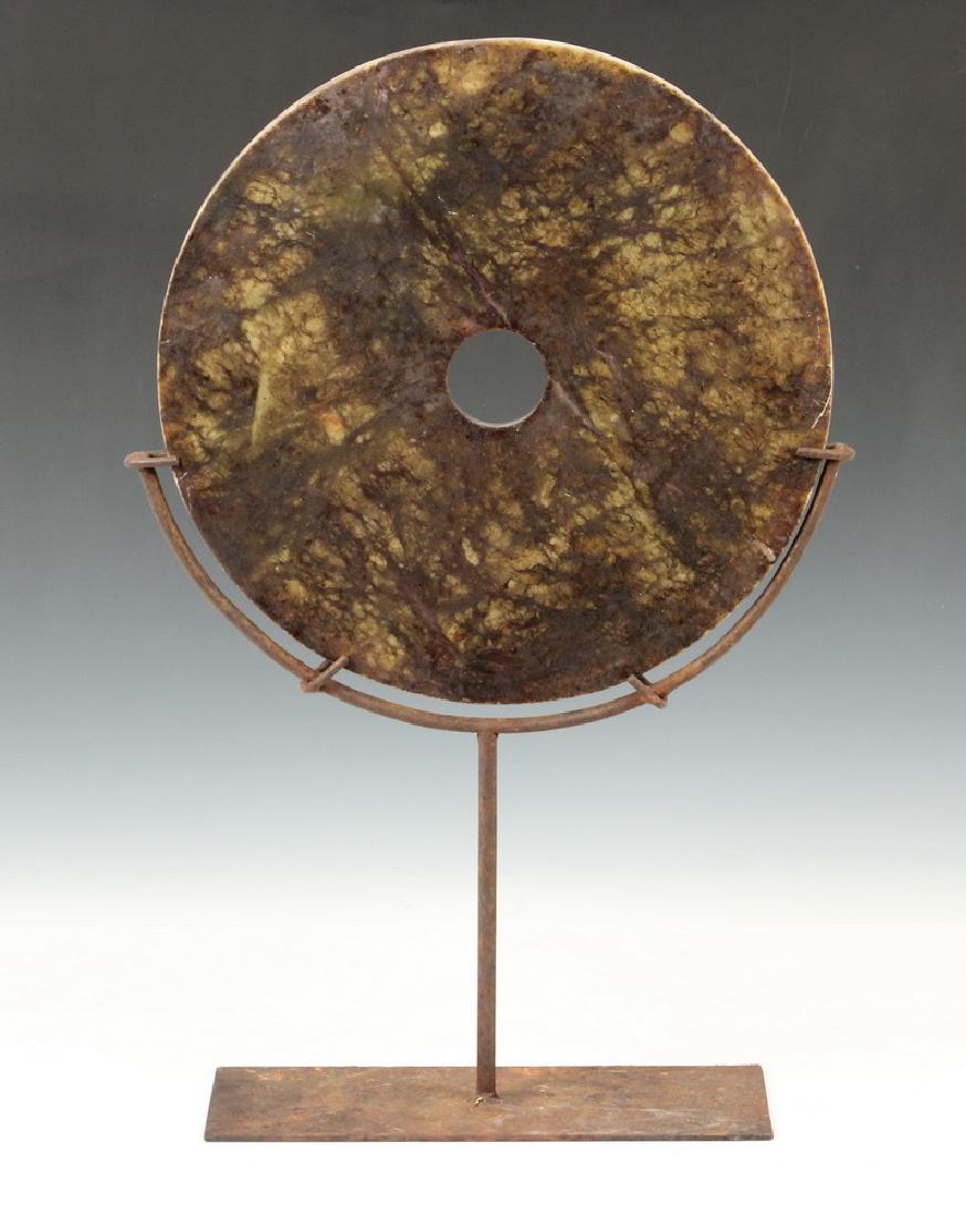 CHINESE BI-DISC ON STAND: Large Chinese Jade Bi-Disc mounted on metal display stand, disc: 11 1/2" diam., on stand: 18 3/4" high. Disc edge scratch, surface rust on stand.