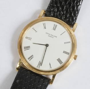 GENT'S WRISTWATCH: Patek Philippe Wristwatch, with an 18K yellow gold round head, white dial with Roman numerals, original black band, 1 1/2" diameter, 8 1/2" overall length. Fine condition.