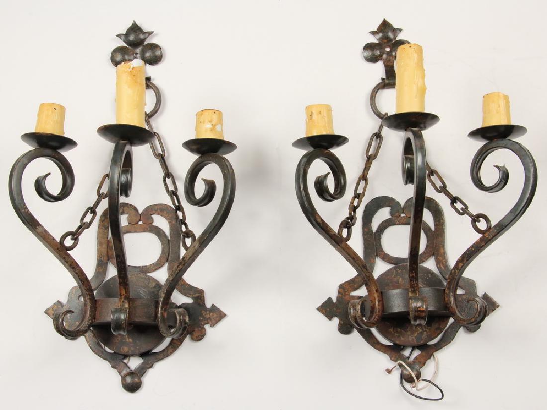 PR OF IRON 3-ARM SCONCES: Pair of 20th c. Iron Triple Arm Wall Mount Electric Candle Sconces, with decorative suspension chains, openwork wall plaque and scroll form candle stems, standard bulb sockets are concealed in wax can