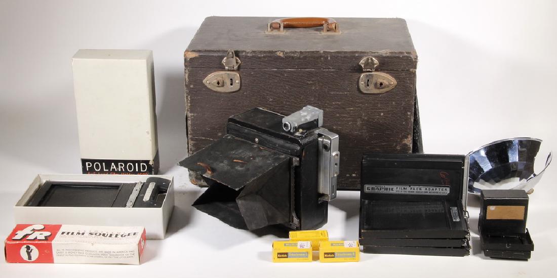 CASED 4" x 5" PRESS CAMERA WITH ACCESSORIES: Burke & James Press Camera, s/n E68169, with Aktinar 13.5 No 219215, Compur, with flash attachment and (7) film carriers, good working condition, bellows intact, some light corrosion to exterior fitti