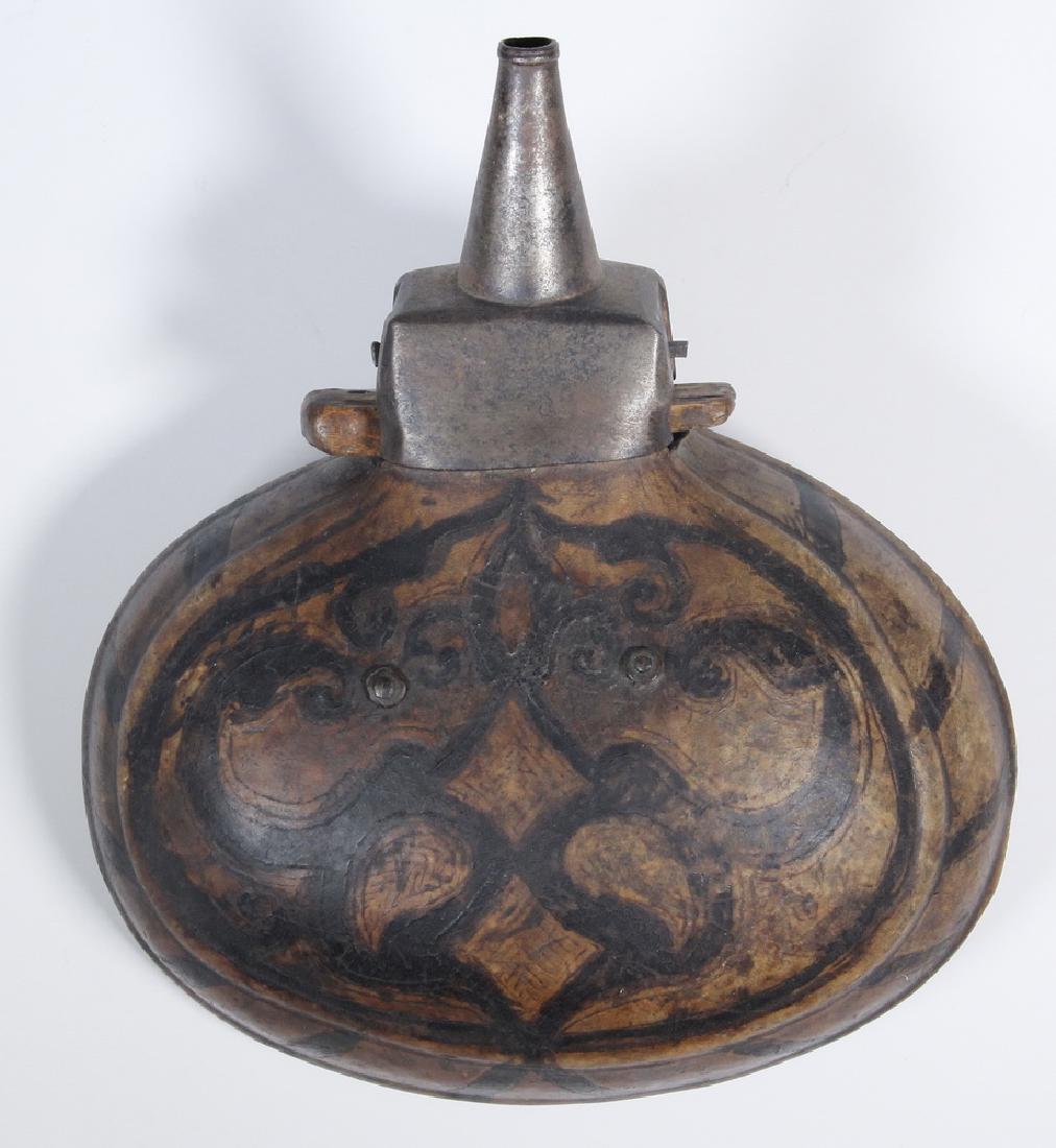 16TH-17TH C. BERBER GUN POWDER FLASK: North Morocco, Tribal Hide Covered Oval Wooden Flask with tooled and painted Ottoman decoration, retaining the original iron spout with wooden flange valve, ring and chain belt hanger on back, roughly