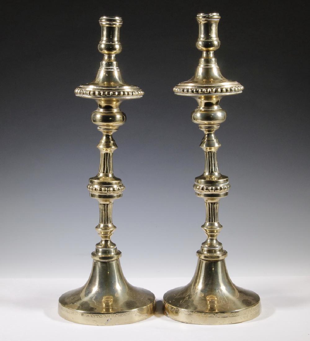 PR SPANISH BRASS ALTAR CANDLESTICKS: Pair of 19th c. Spanish Colonial Heavy Brass Altar Candlesticks, base edges inscribed with presentation to a church in Mexico City in 1834, with ornate stems and large candle cups, 23" high, 8" diam. 