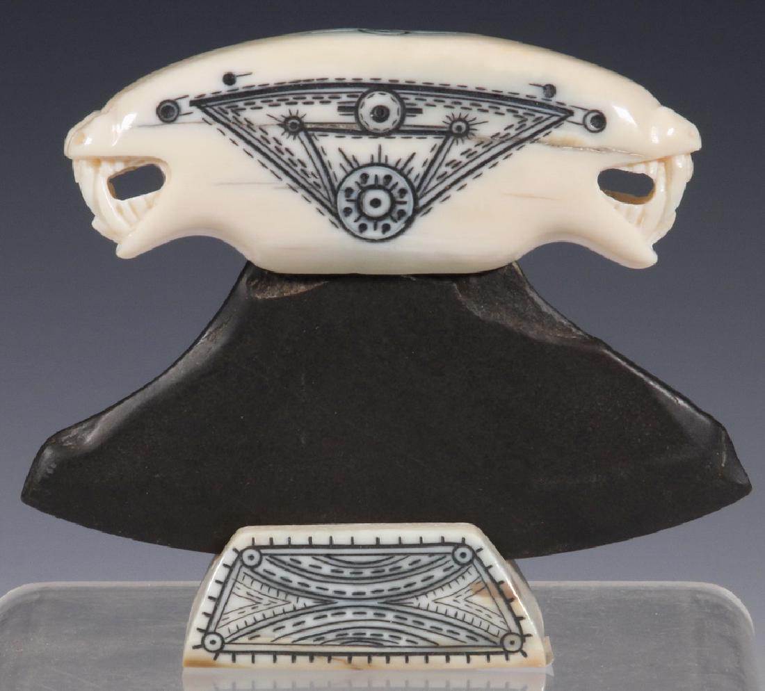 20TH C. ESKIMO WALRUS TUSK HIDE SCRAPER: Inuit Ulu Knife, slate blade with double bear head handle, scrimshaw decoration, signed on matching stand, 4 1/2" wide blade. Good condition.