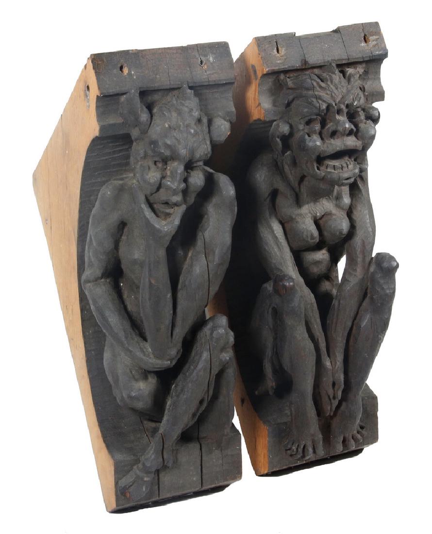 PR CARVED GARGOYLE FORM CORBELS: 19th c. English Oak Gargoyle Corbels, carved in the Gothic style, one male, one female, with expressive features, in dark walnut finish, 15" x 12" x 5 1/2". Shrinkage cracks.