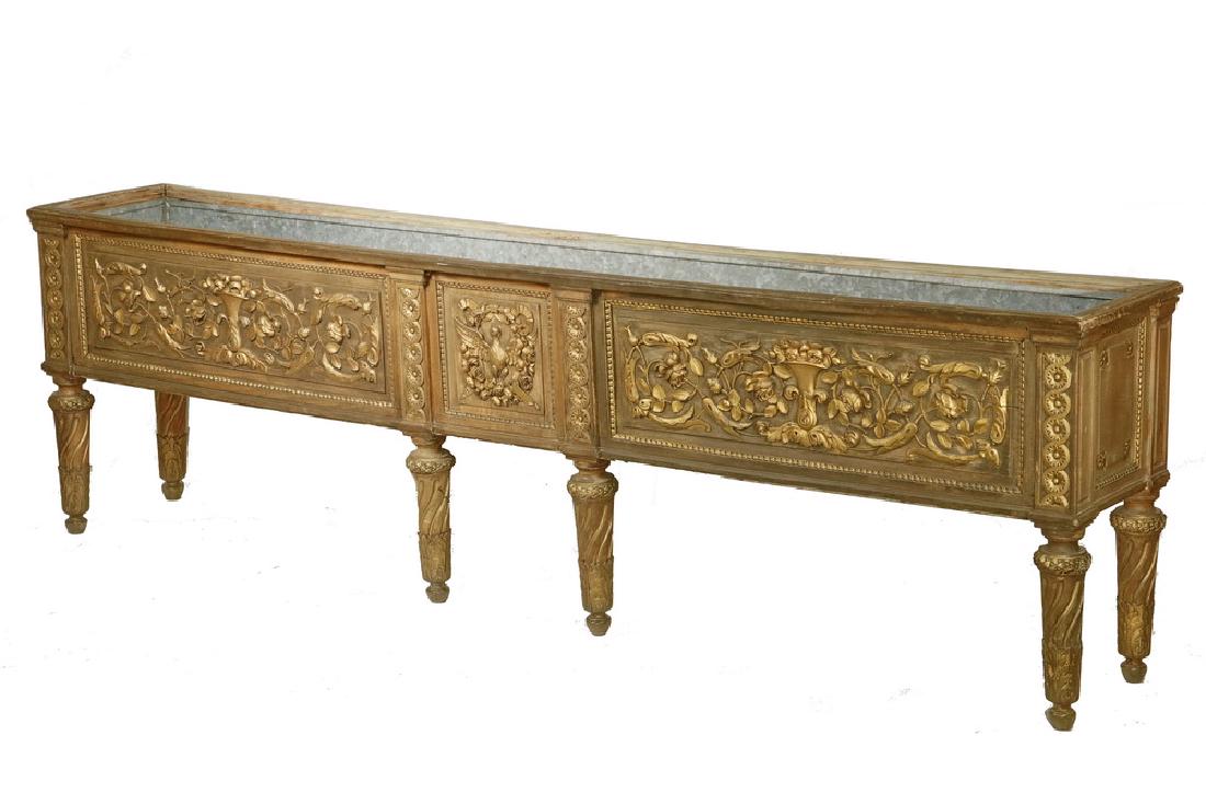 EARLY 20TH C. INTERIOR PLANTER: American Renaissance Revival Long Low Atrium Planter in gold painted carved oak, with the original tin liner, the bas relief three panel front featuring floral arrangements flanking a smaller central 