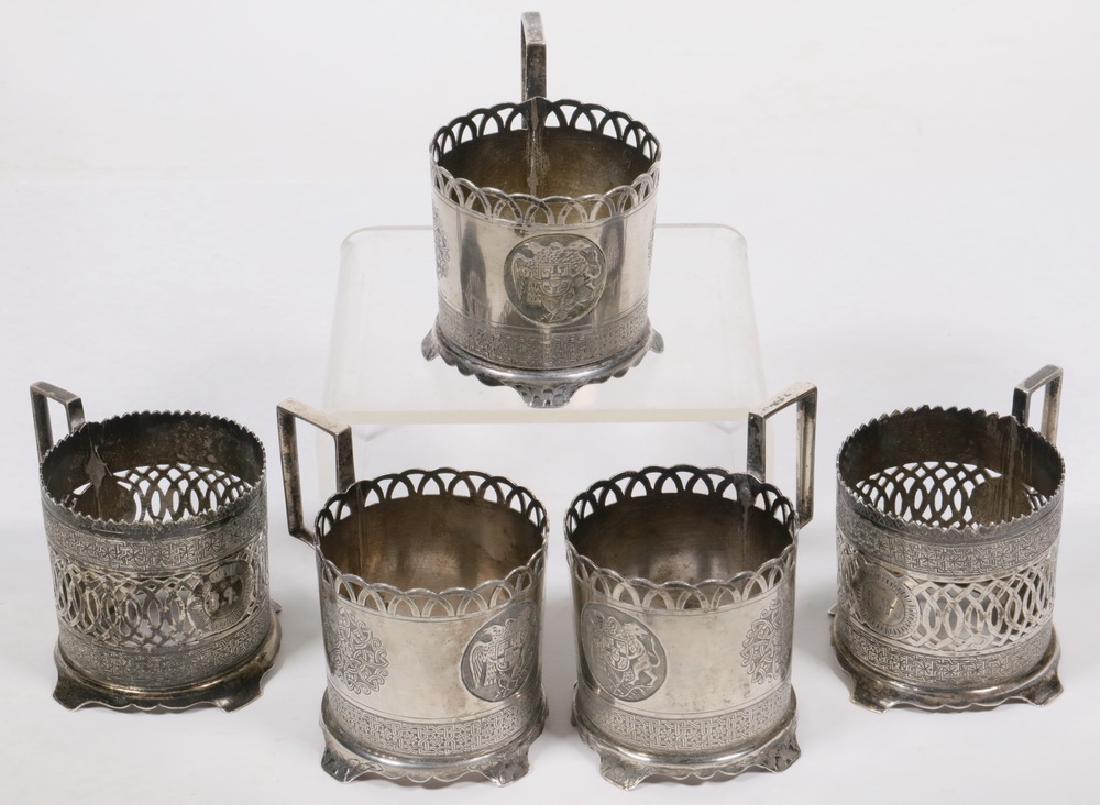 (5) ARMENIAN SILVER TEACUP HOLDERS: Group of (5) Armenian Silver Cup Holders, c. 1900: (3) are engraved with the Armenian coat of arms (eagle and lion supporting a shield) and Persian motif geometric decoration, openwork rims, with Arab