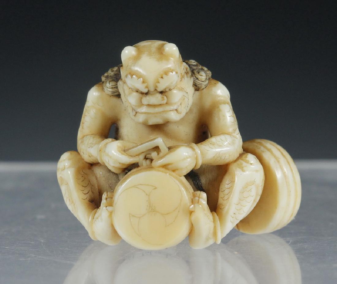 19TH C. JAPANESE CARVED NETSUKE OF A MYTHOLOGICAL: Early Meiji Period Seated Figure of Drum Maker Oni, depicted working on one drum, a second resting against his knee and elbow, signed on the underside. Provenance: From the estate of Nancy Hamilton.