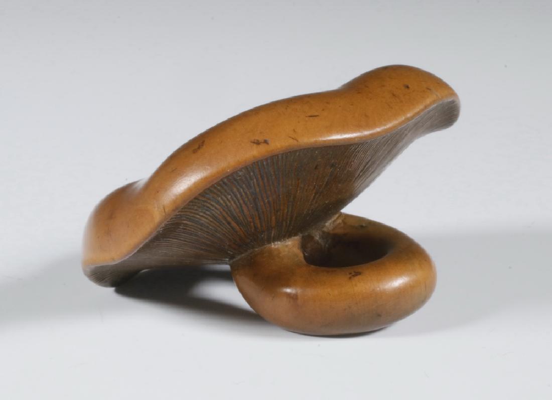19TH C CARVED WOOD NETSUKE OF MUSHROOM: Meiji period Manju Netsuke in carved pear wood of a mushroom with curled stem as slide, 1 7/8" diam. Lovely warm patina. Provenance: From the estate of Nancy Hamilton.