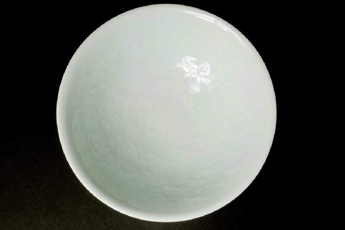 JAPANESE WHITE PORCELAIN BOWL: Meiji Period Figured with whimsical fish on the interior, white glaze on white clay, having a flared rim, with a tall foot, having an impressed cartouche signature on the underside, 2 3/4" x 8 3/4" di