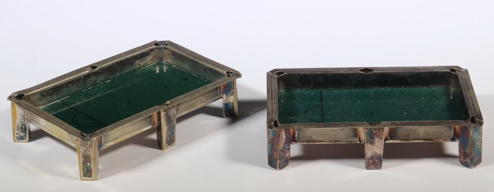 (2) SILVER PLATE POOL TABLE FORM ASHTRAYS: Unmarked, circa 1930s, green reverse painted glass beds with snooker markings, 1 1/4" x 5 2/4" x 3 5/8". Wear to silver plate, loss to green at edges.