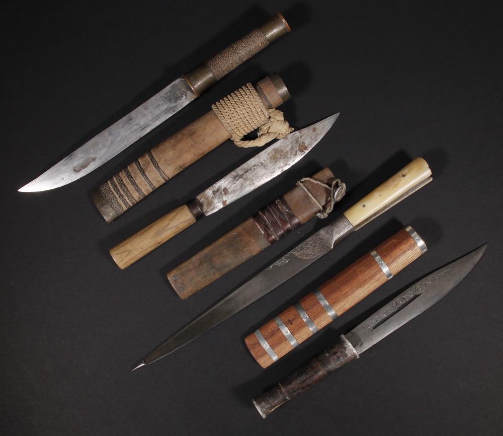 (4) ETHNIC STRAIGHT BLADE KNIVES: Three Malaysian Fisherman's Knives with crude single edged steel blades (one engraved with a fish), various wooden grips, one with brass and wire winding, flat square-bottomed wooden sheaths with copp