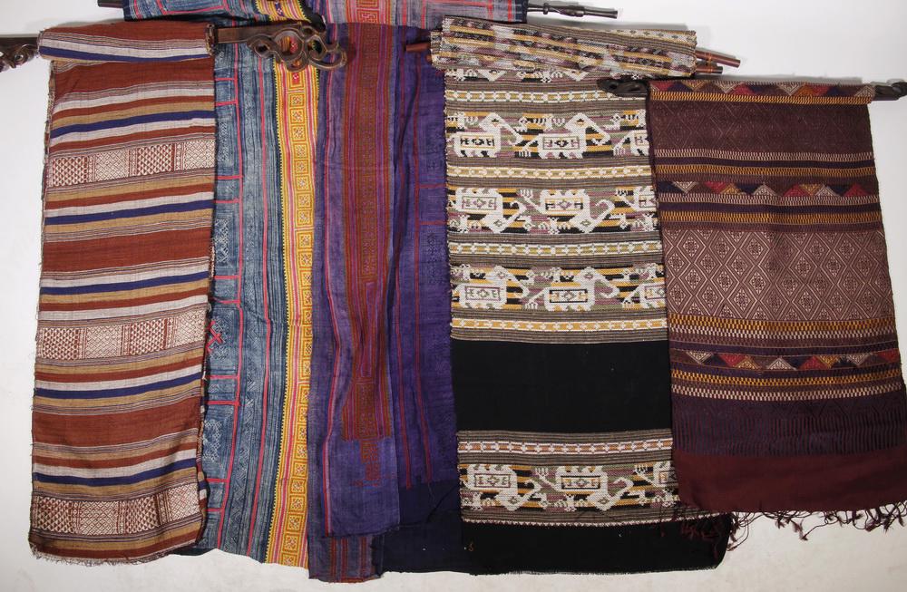 (10) INDONESIAN TEXTILES, (8) WITH WOODEN HANGERS: Collection of (9) Indonesian Woven Textiles, three with bamboo hangers, five with carved wooden hangers, some with embroidery and/or fringe, textile sizes range from 11" to 21 1/2" wide and 49" to 127
