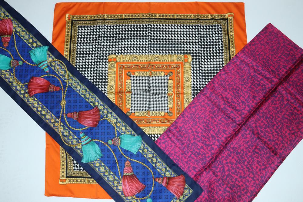 (9) ASSORTED SCARVES: Collection of (9) Silk and Polyester Scarves, including: Unmarked square silk scarf in orange, gold, black and white, incorporating buckles and a houndstooth plaid design, 34" sq.; Unmarked square sil