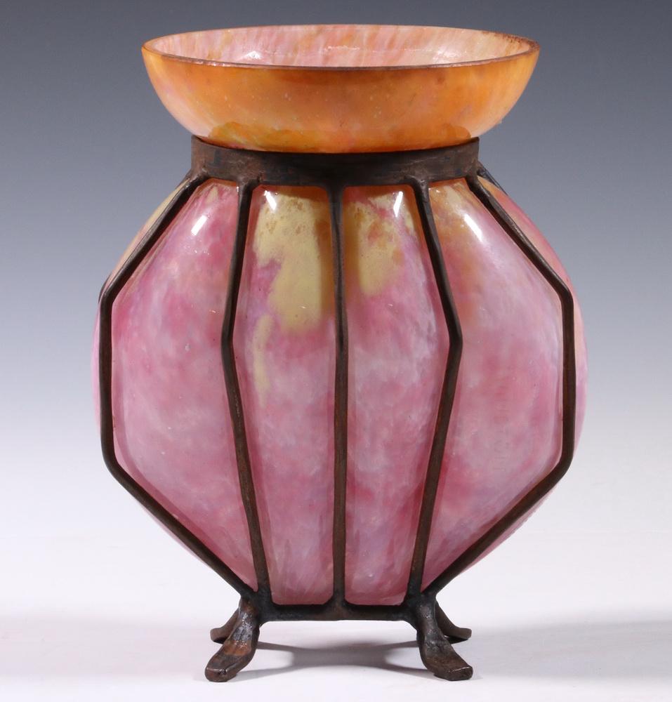 BLOWN OUT IRON MOUNTED ART GLASS VASE: Circa 1920s Period Continental Art Glass Vase, in mottled pinks and yellows blending to a tangerine and gold rim, blown into a wrought iron frame in the manner of Charles Schneider and Andre Delatte,