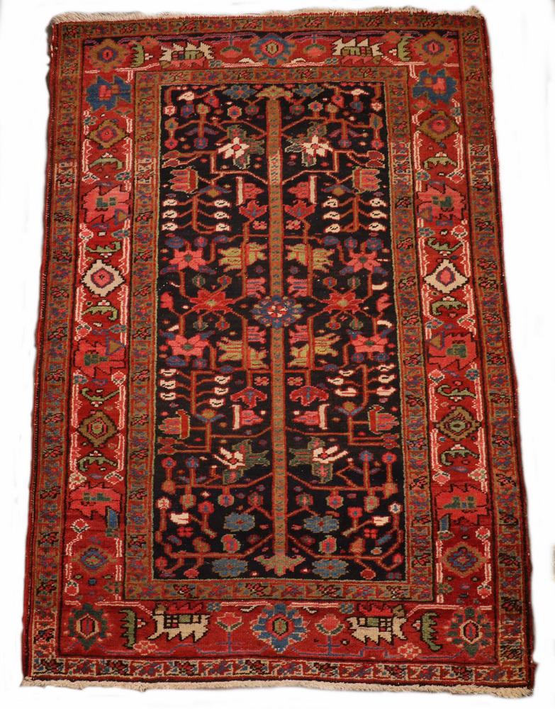 HERIZ RUG - 3'-7" x 5'-4": Northwest Persia, second quarter 20th c., center pole flanked by palmettes and flowering vines in rust, ivory, Persian blue and gold on the midnight blue field, rust vine and palmette border. Good con