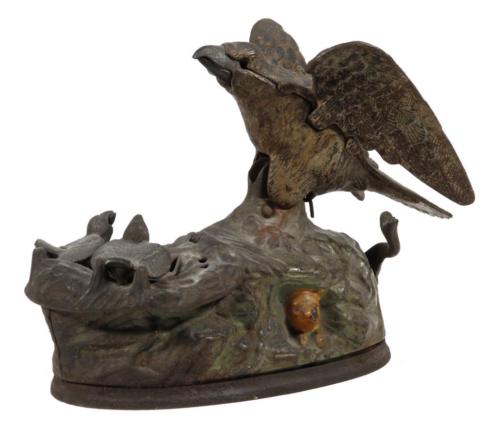 EAGLE & EAGLETS CAST IRON MECHANICAL PENNY BANK: 'Eagle and Eaglets' or 'American Eagle', patented Jan 23, 1883, designed by Charles M. Henn, manufactured by the J&E Stevens Co. of Cromwell, CT; in scarce remnants of original paint, 6" tall, 8" x 4"