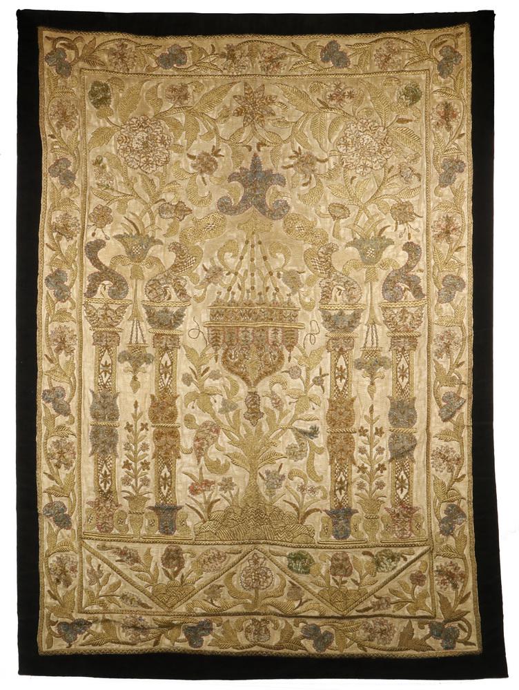 MUGHAL METAL THREAD EMBROIDERED WALL HANGING TEXTILE: Magnificent panel in tan silk with ornate detailing in gold and silver thread over blue and red backing, depicting in relief a set of four stepped columns with animal capitals, in a rich field of foli