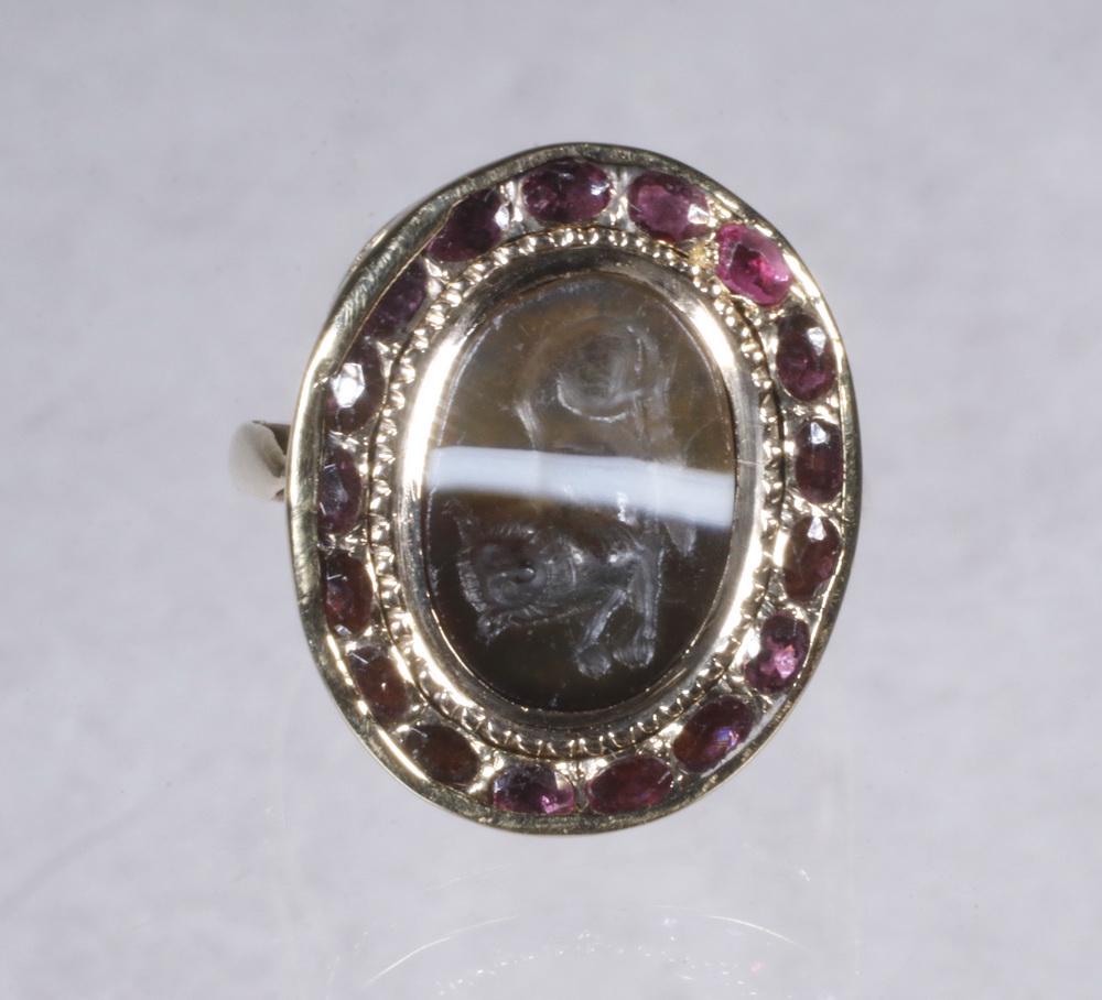 18TH C. 14K GOLD INTAGLIO RING: 18th Century Intaglio Ring in 14K yellow gold, surrounded by (17) small garnets. Size 5 1/2.