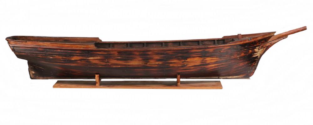 19TH C. MASSACHUSETTS BUILDER'S MODEL: Plank Built Full Hull Model on a stand, in spruce, of a coastal freight schooner, with raised poop and foredecks, bowsprit, the planks nailed to frame having created a tortoiseshell effect to the colo