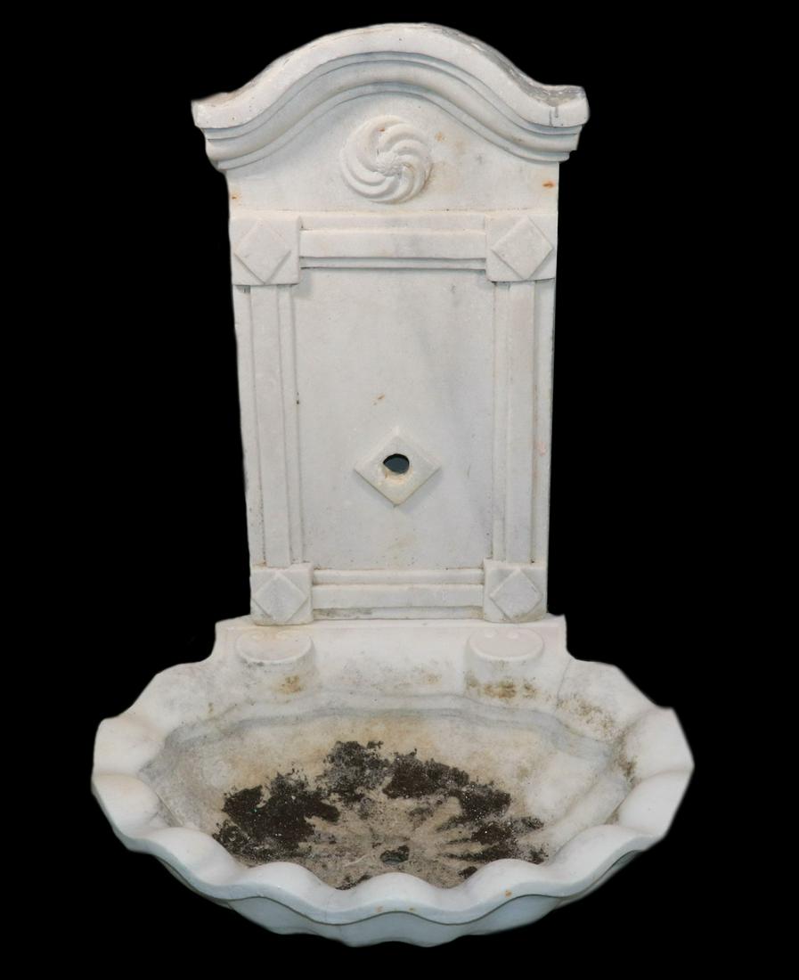 CONTINENTAL TWO-PIECE MARBLE WALL FOUNTAIN: Wall Mounted Marble Fountain, 19th c., top section with carved arch top with raised rosette, above raised geometric motifs centered by spout, shell form base with drain hole, top: 26 1/2" high, 15" x 
