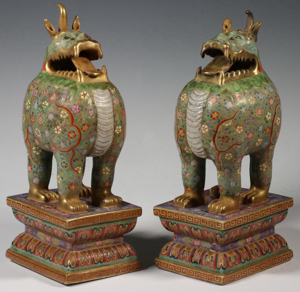 PR CHINESE CLOISONNE ENAMELED PORCELAIN FOO DOGS: Pair of Chinese Republic Era Enameled Porcelain Standing Foo Dogs, early 20th c., on rectangular plinths, bodies with floral decoration on a green ground, gilded teeth, tongue, ears, horns and feet, s