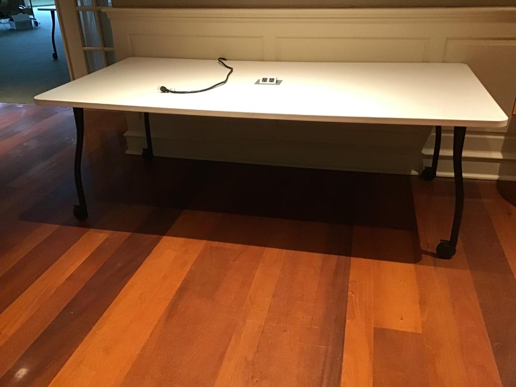 6 PORTABLE WORK TABLES: Lot of six (6) laminate top work tables with center pop-up AC outlets set on four metal legs with lockable casters