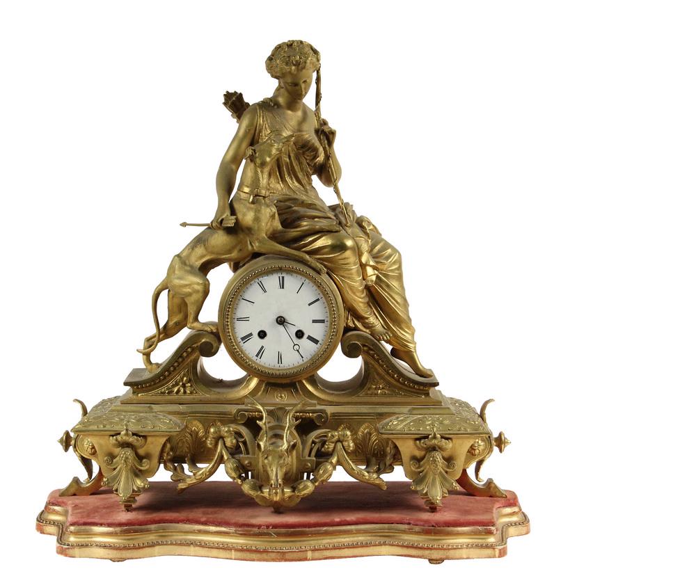 FRENCH GILT MANTEL CLOCK: Diana the Huntress and Her Dog Syrius seated atop the drum form clock with enameled dial, eight day time and strike brass movement, no glass, set into a swan pediment, lower plinth featuring an elk he