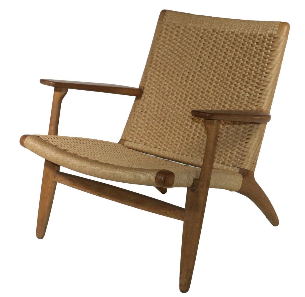 HANS WEGNER (DENMARK, 1914-2007) CH25 CHAIR: Oak CH25 Lounge Chair by Hans Wegner, crafted by Carl Hansen & Son, Odense, Denmark, with wide flat arm rests, tapered legs with the original woven papercord cord seat and back, with 'Carl Hansen & So