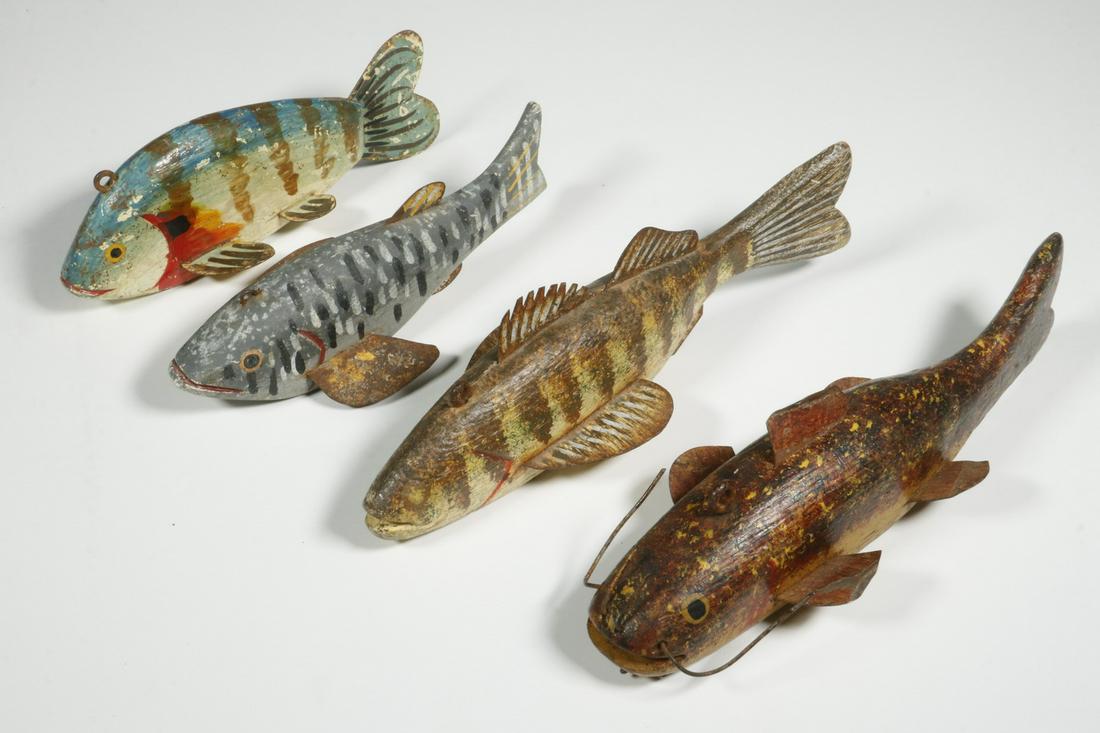 FISH DECOYS: Lot of (4) Fold Art Carved and Painted Fish Decoys with applied sheet metal fins and inset lead belly weights. Ranging in length from 6" to 8". Good condition. Painted surface with some flaking and we