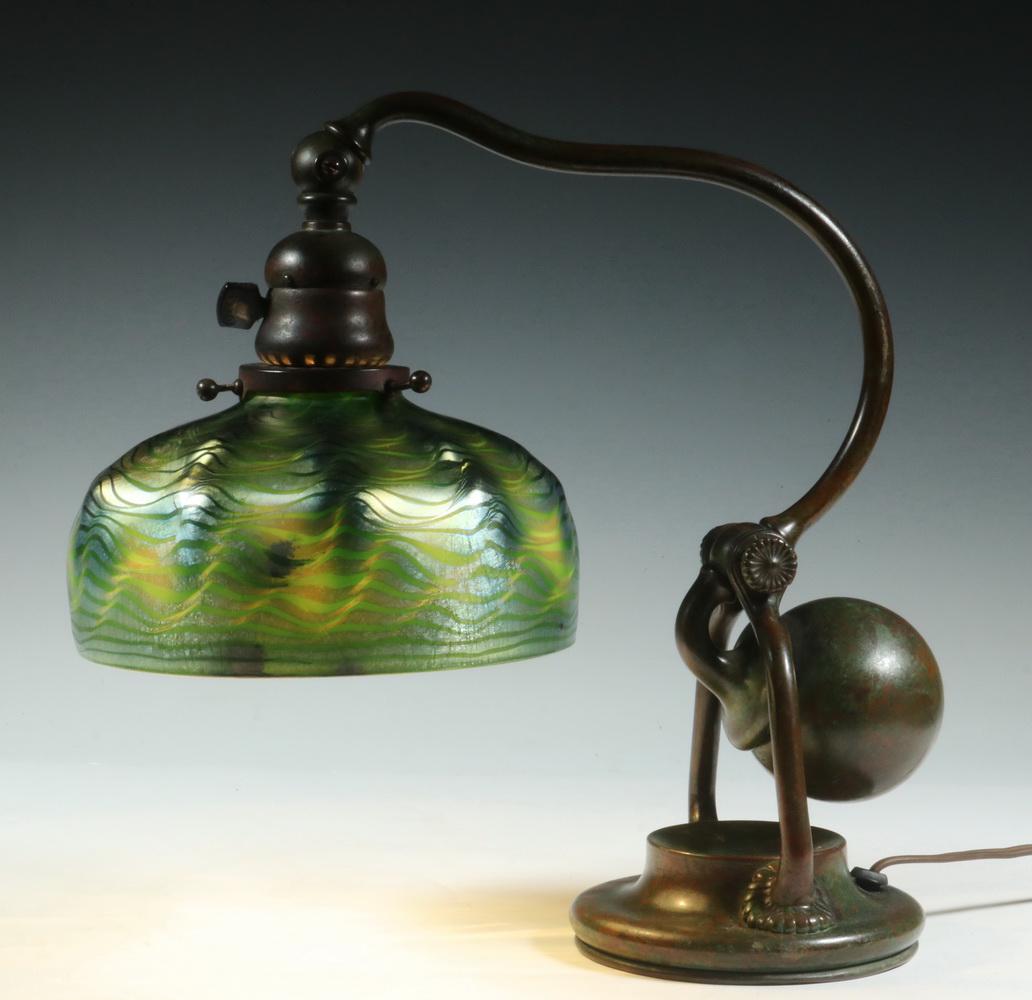 TIFFANY STUDIOS COUNTERBALANCE LAMP WITH FAVRILE SHADE: Circa 1910 Tiffany Studios Bronze Counterbalance Desk Lamp with Art Glass Shade, verdigris patinated lamp surface with base stamped '4487, Tiffany Studios, New York", shade top rim interior etched 'L.