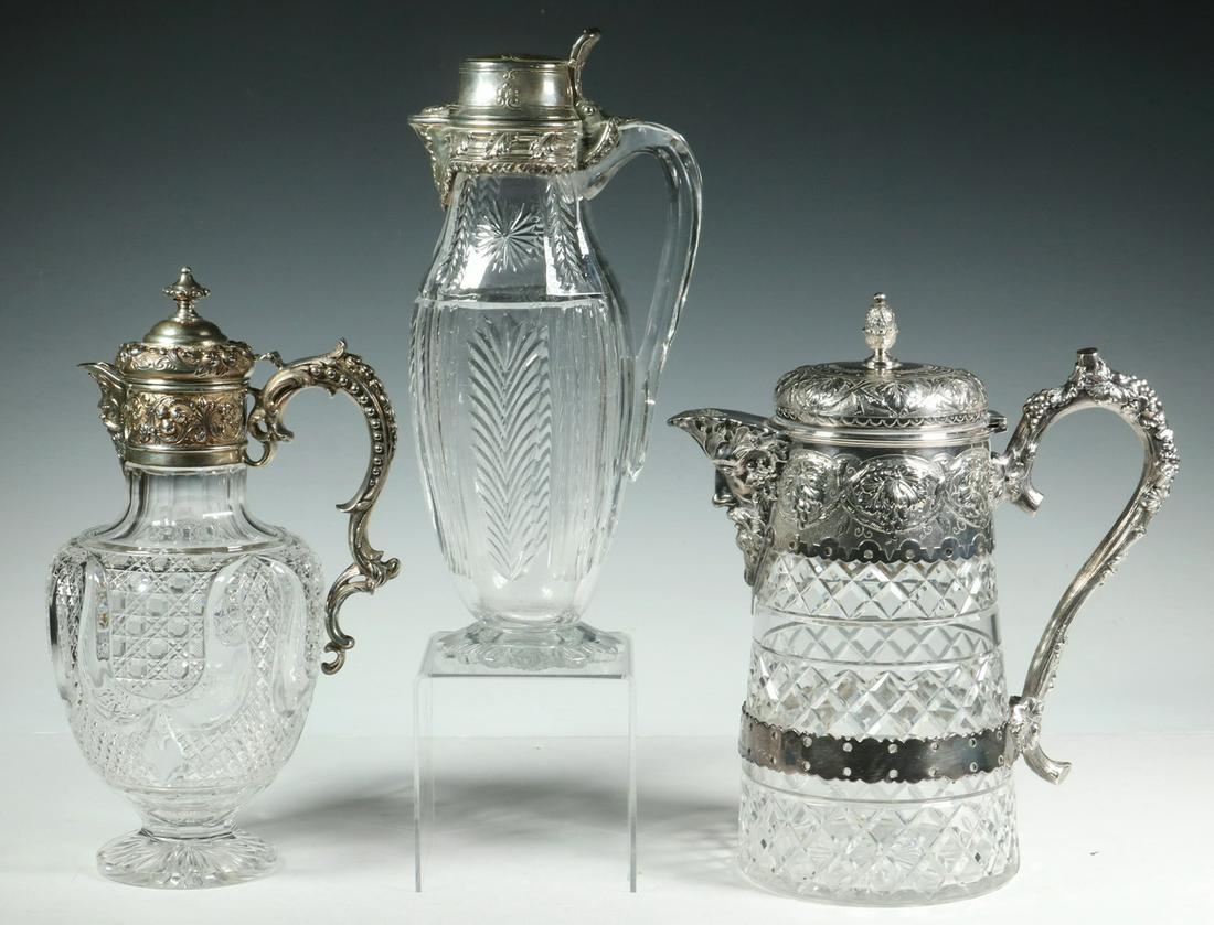 (3) SILVER MOUNTED CUT CRYSTAL EWERS: Group of (3) Silver and Clear Cut Crystal Lidded Carafes, incl: Tiffany & Co. sterling mounted carafe, #8805M8723, with star, leaf and ribbed cut crystal body, 11 1/2" high, 5 1/2" x 3 1/2"; English M