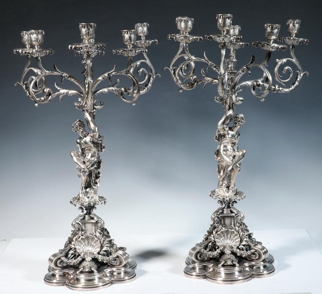 PR SILVERED BRONZE BANQUET CANDELABRA: Pair of Rococo Style Six-Arm Figural Candelabra, depicting male and female Classical figures atop bases festooned with shells, turtles and swags, each with scalloped shaped foot, 21 1/2" x 13 1/2" dia