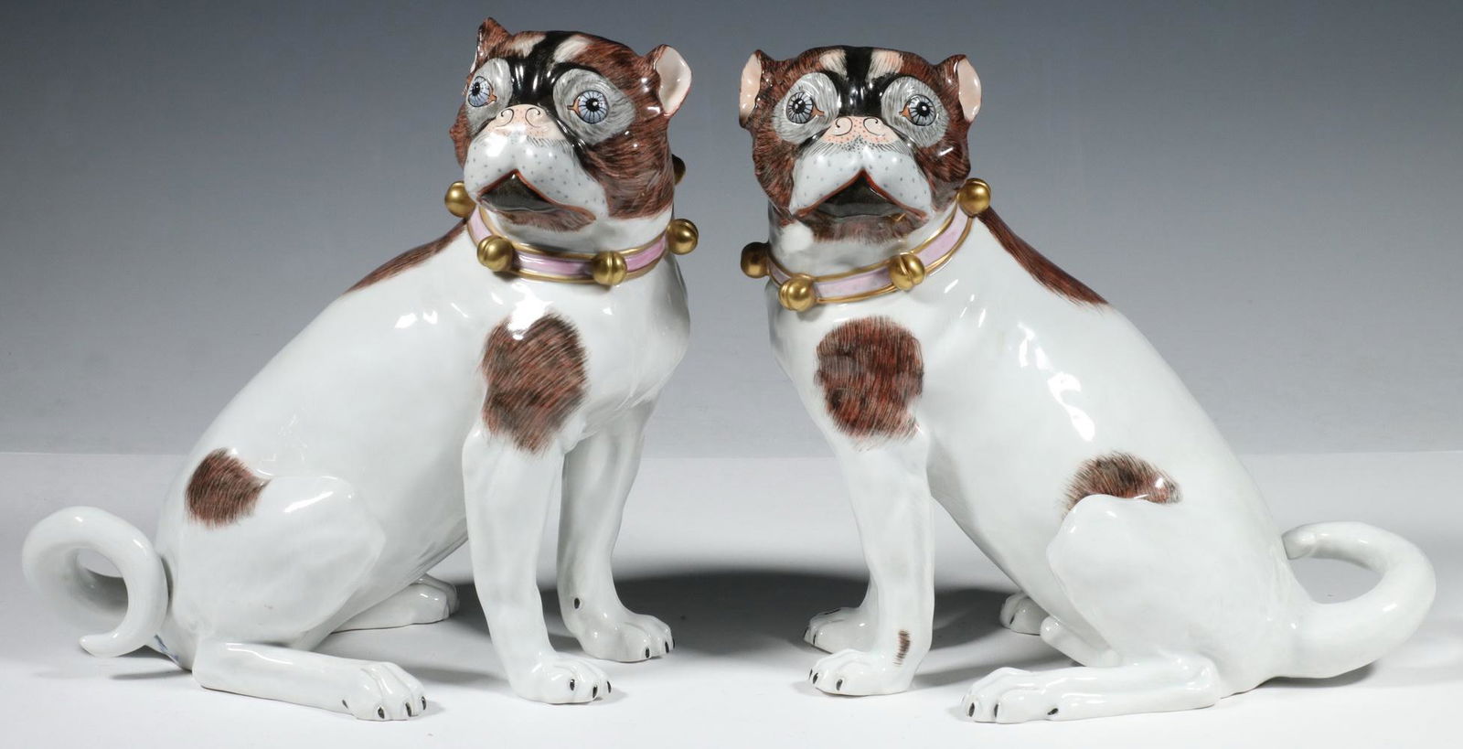 PR DRESDEN PORCELAIN PUGS: Matched Pair of Dresden German Porcelain Pugs, designed by Carl Thieme of Potschappel, Saxony, hand painted with gilded ball form collars, left facing dog impressed 'D1455', right facing dog impressed