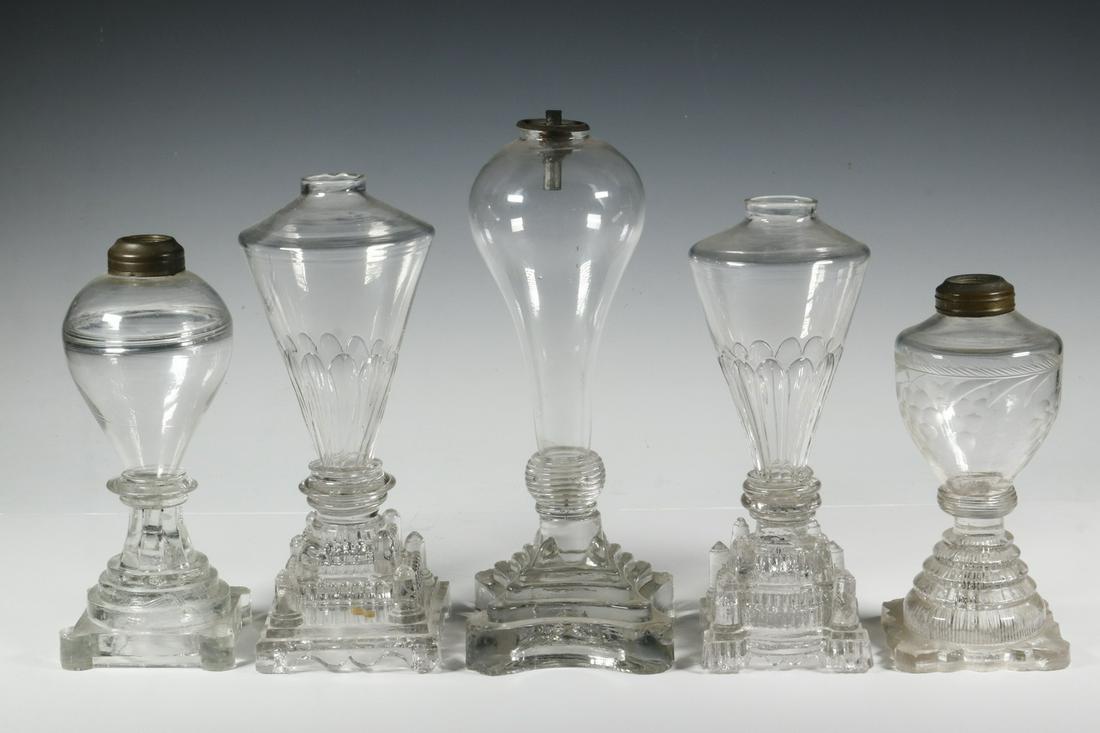 (5) BLOWN & PRESSED GLASS WHALE OIL LAMPS: Group of (5) Early to Mid 19th c. Clear Blown & Molded Glass Whale Oil Lamps, incl: (2) High shouldered glass fonts tapering to petal molded bottoms, and three-stepped base with column form corners an
