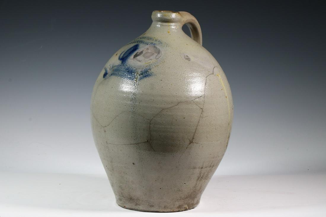 L. NORTON & SON STONEWARE JUG: One-gallon ovoid salt glazed jug with handle by L. Norton & Son, Bennington, VT. Cobalt blue slip trail design with an accent cobalt on the maker's mark.14 1/2" high. Two occlusions on the front in th