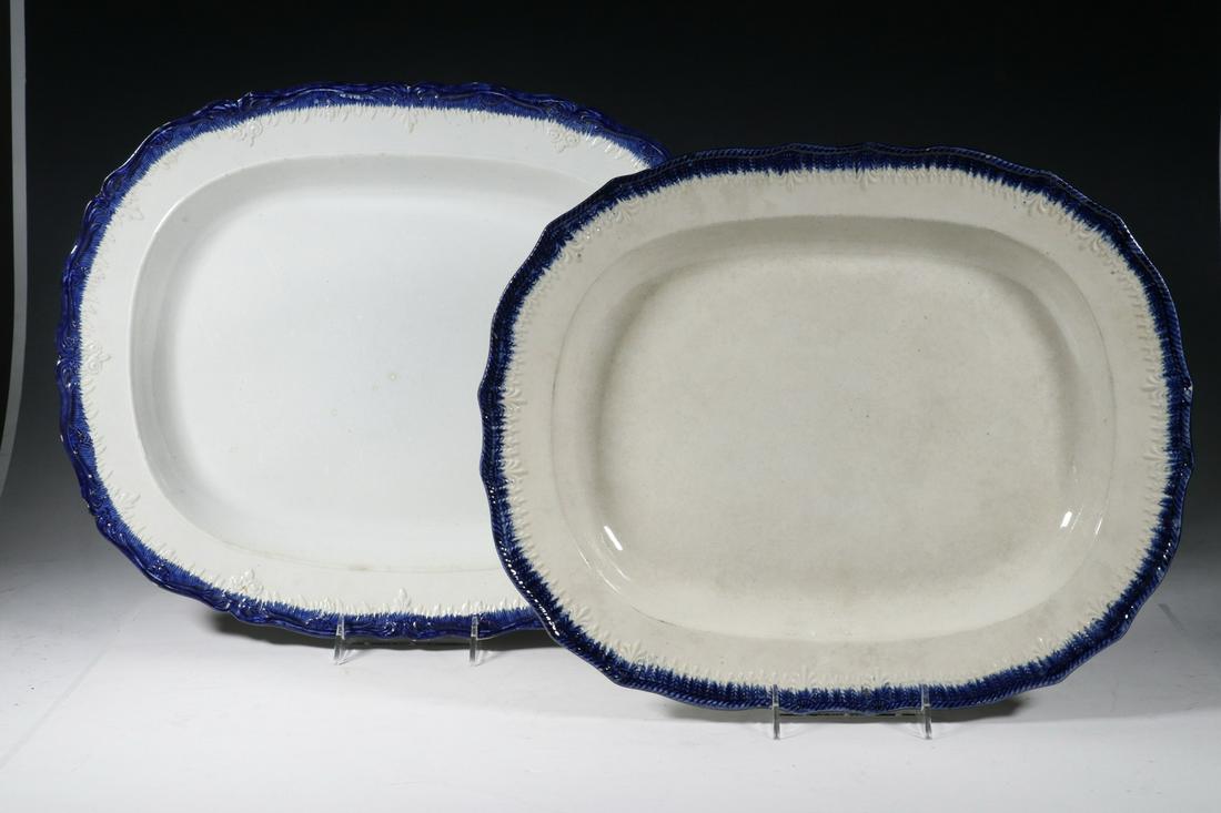 (2) LEEDS FEATHER EDGE PLATTERS: Lot of (2) Early 19th c. Leeds Blue Feather Edge Platters, shaped rims with embossed edge decoration, unmarked, 14 1/4" x 17 1/2" and 15 1/2" x 19 1/4". A few rim glaze frits. Provenance: From the est