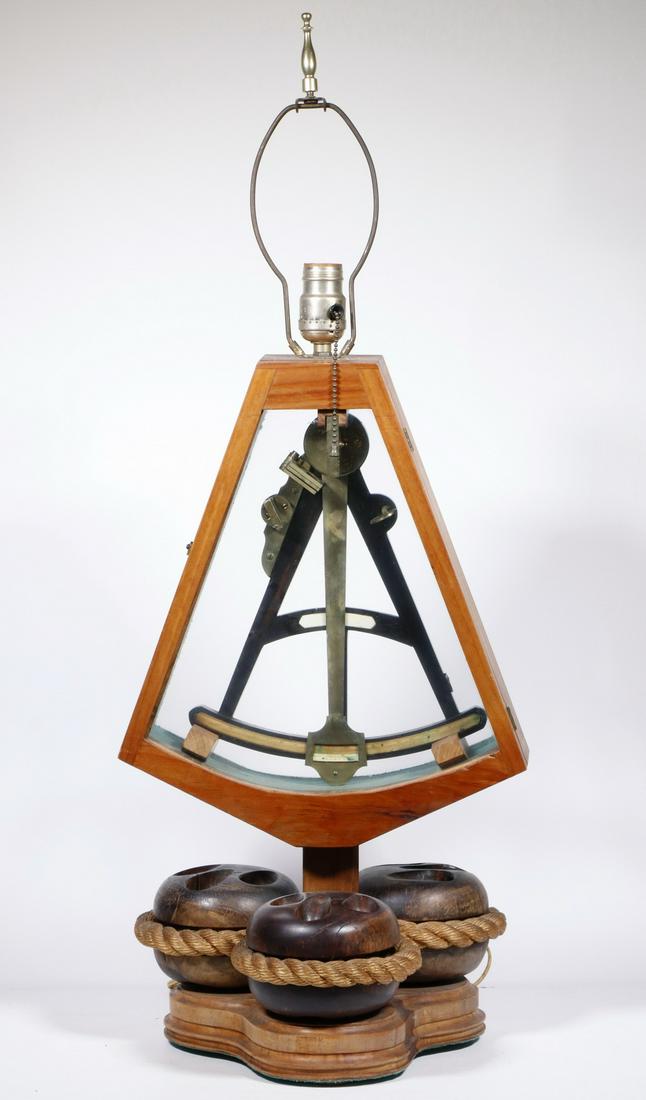 NAUTICAL TABLE LAMP: 20th c. Table Lamp with Cased Sextant, brass and wood sextant in a custom wooden case with front and back glass panels, set on a base composed of three antique lignum vitae deadeye pulley blocks surro