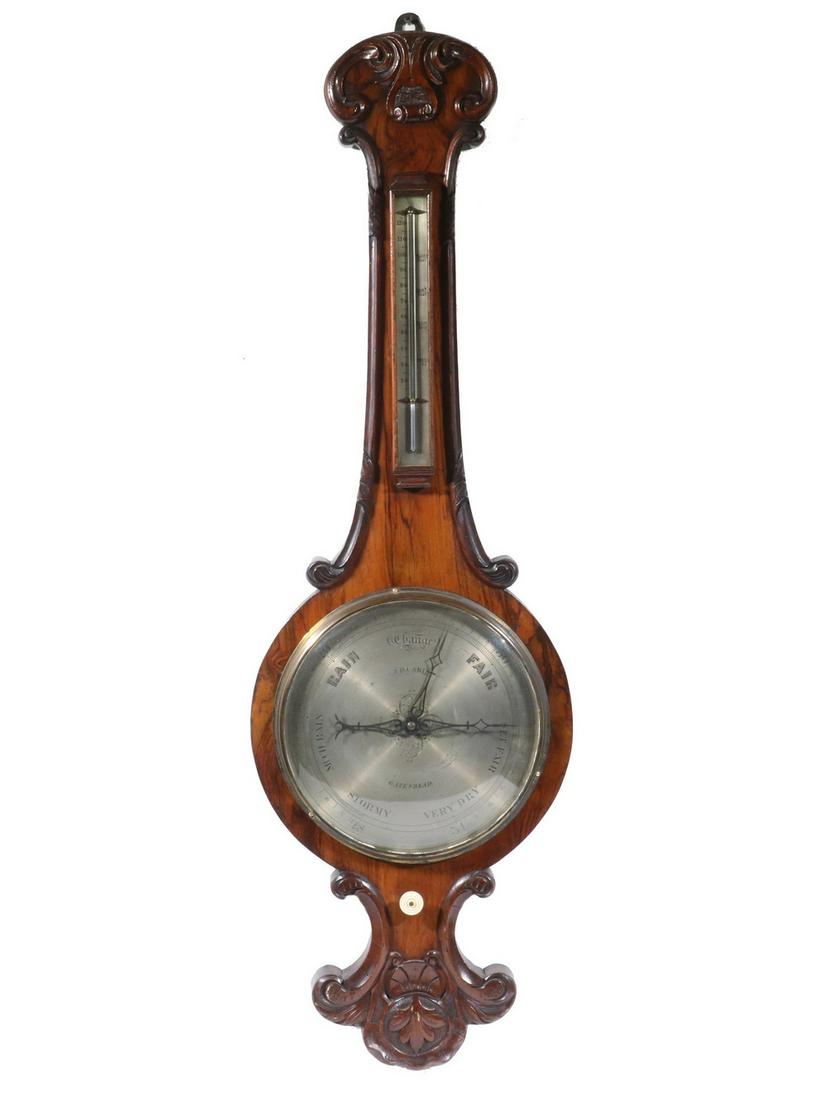 VICTORIAN WHEEL BAROMETER, J.D. CARIS, GATESHEAD: Circa 1870 Rosewood Cased Banjo Form Barometer, with silvered dial marked 'J.D. Caris, Gateshead', brass bezel, neck mounted thermometer, case edged in carved scroll moldings, 39" high x 12", 1 1/2" d