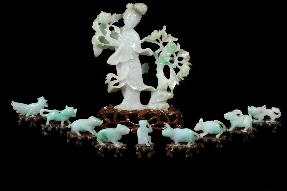 19TH C. JADEITE GUANYIN WITH FLORAL DECORATION ON WOOD: Chinese, green and white carved stone, the guanyin standing next to a flowering tree, holding a lotus blossom, cracked where bush meets woman, adhered to stand, 6 1/4" x 4 1/4" x 1 3/4"; PLUS (10) Tin
