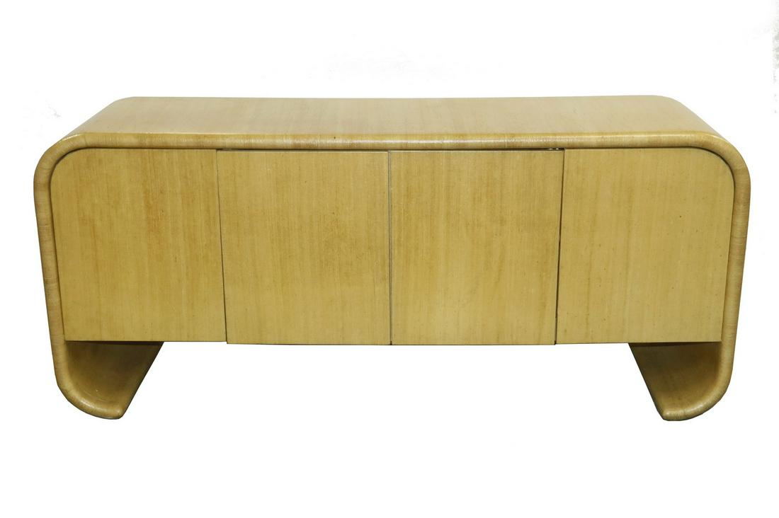 KARL SPRINGER CREDENZA: Waterfall Credenza of wood construction covered in lacquered tussah silk, circa 1970, unmarked, in the form of a continuous rounded edge slab, the ends rounded top and bottom, with curled ends, two se