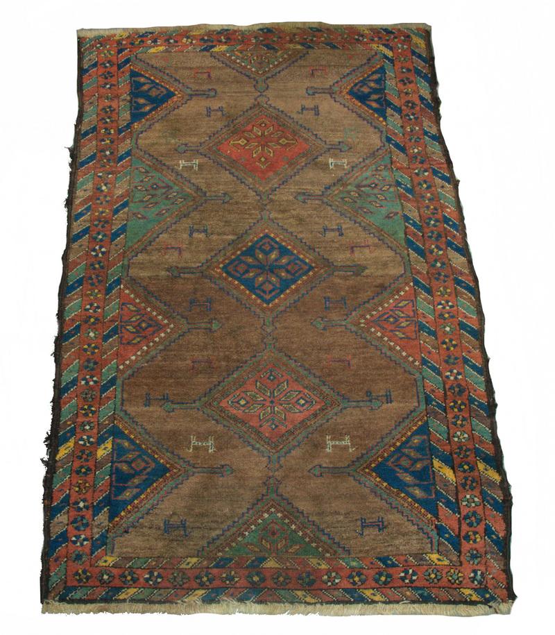 KURD RUG - 3'-10" x 6': Three stepped diamond medallion in navy blue, rust red and gold on the camel field, rust red rosette border. Good condition.
