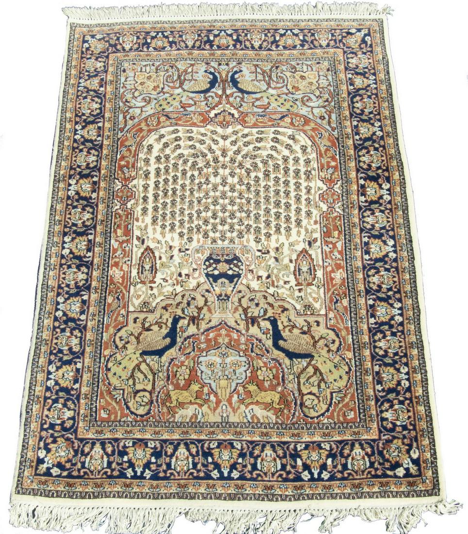 'TREE OF LIFE' RUG: Weeping willow tree on the ivory field, with peacocks and guard dogs in rust, gold, midnight blue, midnight blue vine and palmette border, 4'-2" x 6'-7". Good condition.