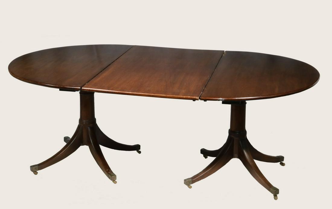 MAHOGANY DUNCAN PHYFE DINING TABLE: American two-part banquet table with two leaves set on double pedestal base with four splayed legs having brass toe casters. The table is 29" tall, 50" x 25" each demilune, the two leaves are 27" each