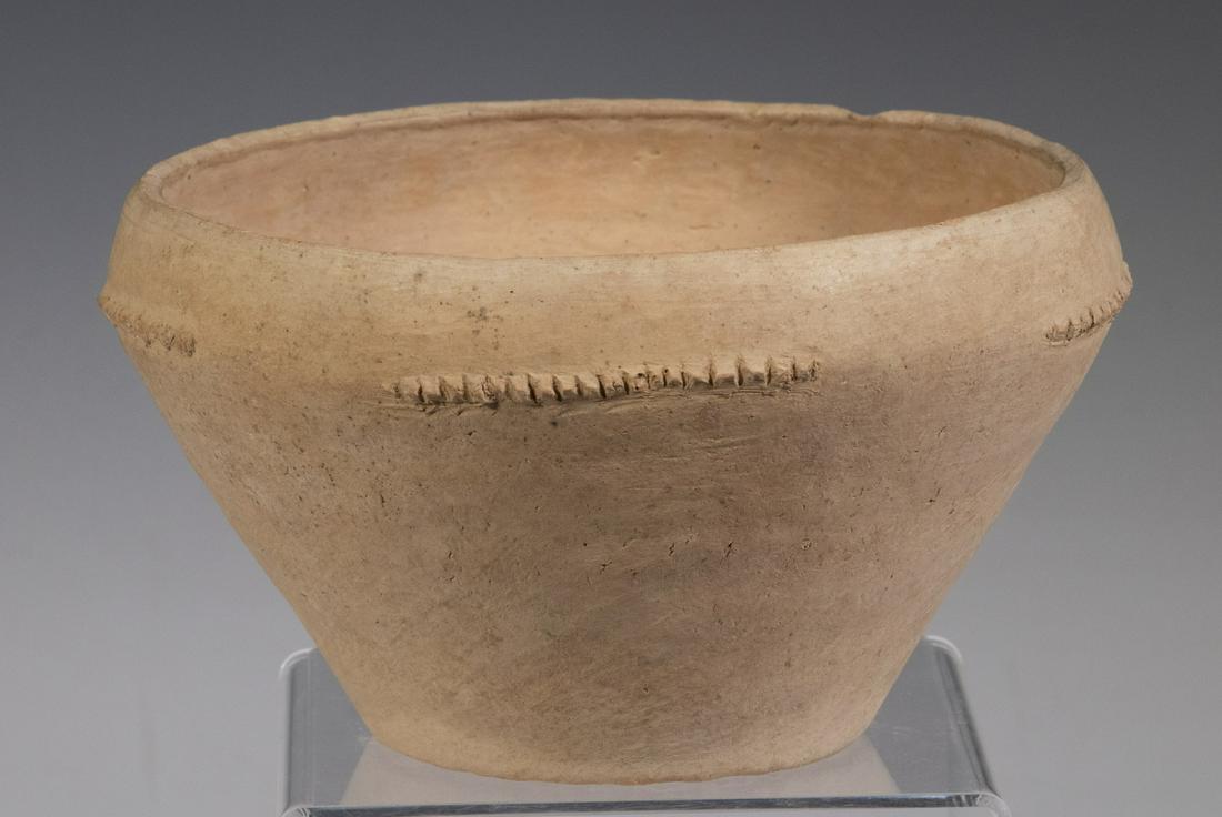 CHINESE NEOLITHIC POTTERY BOWL, QIJIQ CULTURE (2200 BC: Terracotta Bowl in white slipped terra cotta, with a broad mouth, stop and start roping trim at shoulder, a single set of two applied dots on one side, worn reed textured flat foot, 4" x 7" diam. Good