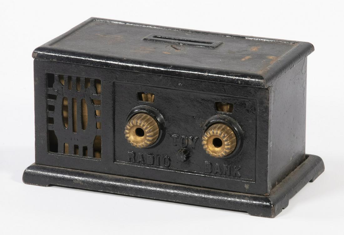 CAST IRON RADIO FORM STILL BANK: Circa 1928 Toy Radio Bank by J&E Stevens (Cromwell, CT), with two dials and speaker front, black and gold surface, 2 7/8" high, 5 3/8" wide. Paint losses.