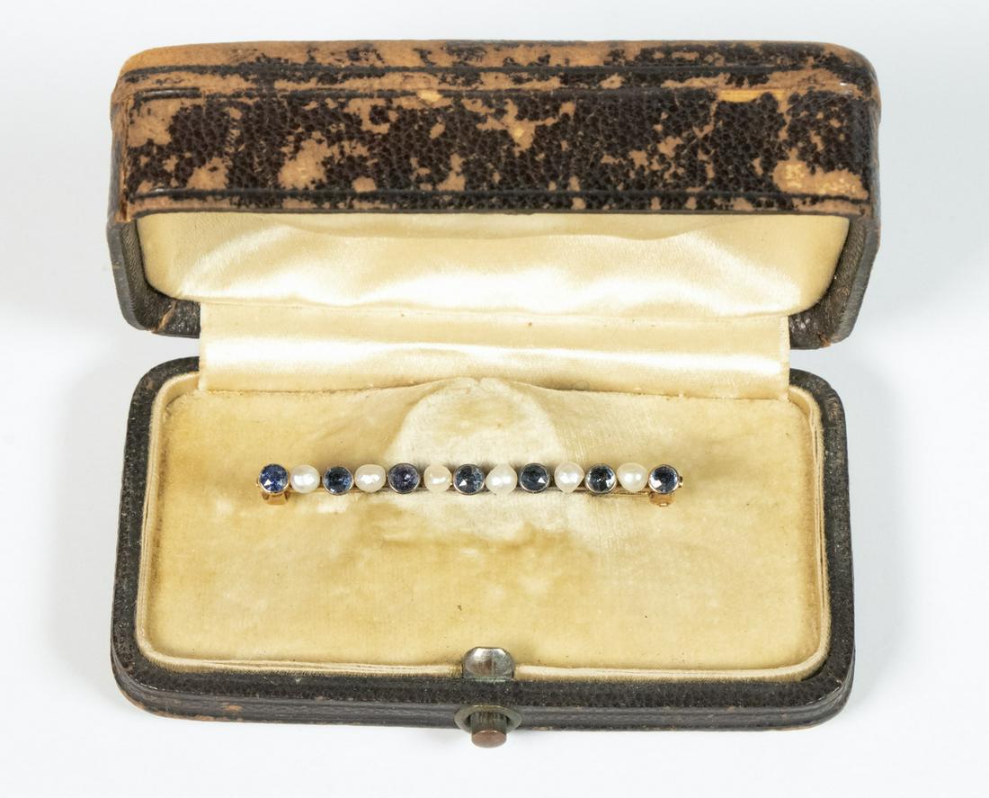 VICTORIAN PEARL & SAPPHIRE BAR PIN: 14K Yellow Gold Bar Pin, set with alternating small pearls and round faceted blue sapphires, 1 5/8" wide, 1.5 dwt tw; in a fitted leather covered case. Case surface wear, pin in good condition.
