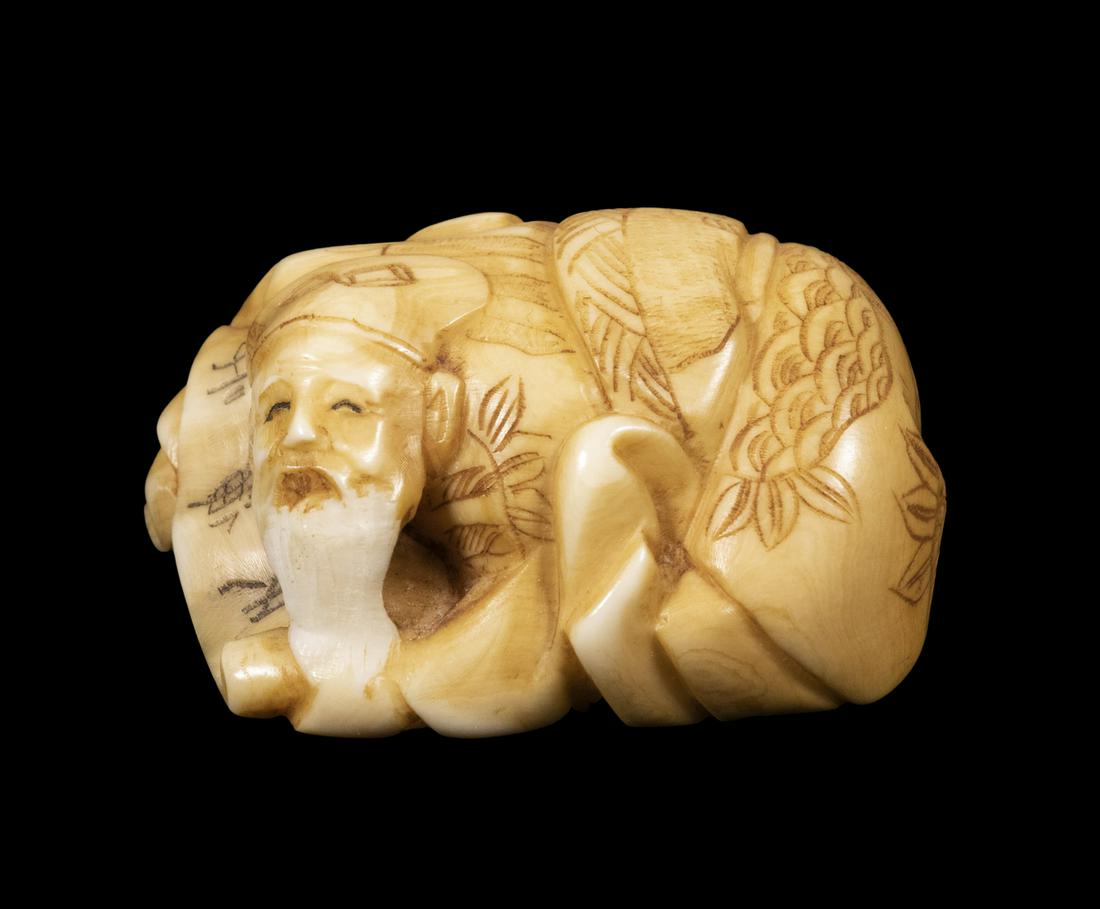 19TH C. JAPANESE IVORY NETSUKE, SIGNED: White Bearded Shinto Priest laying prone with folded legs over an unrolled scroll, signed on the underside, 1 3/4" x 1 1/2", very good condition.