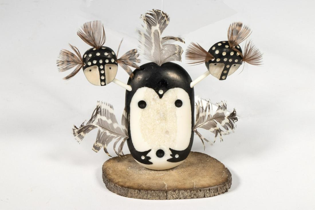INUIT CARVED MASK BY MATTHEW LIULANA: Seal Spirit Mask in walrus ivory, baleen and feathers, with bone stand. Signed and titled verso, 4" tall (including feathers). Good condition.